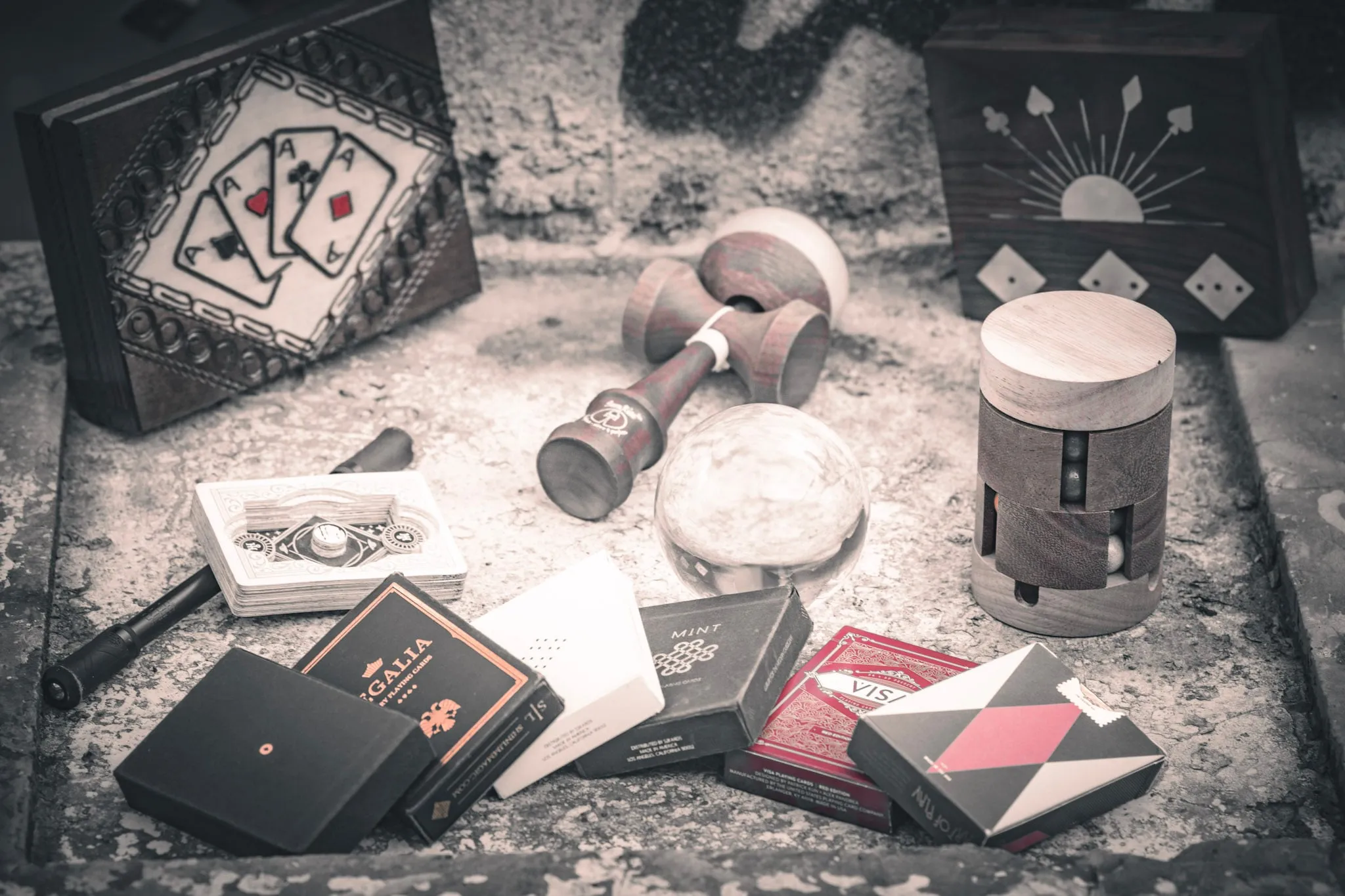 Kartendecks, Würfel und Requisiten auf einem Steinboden.